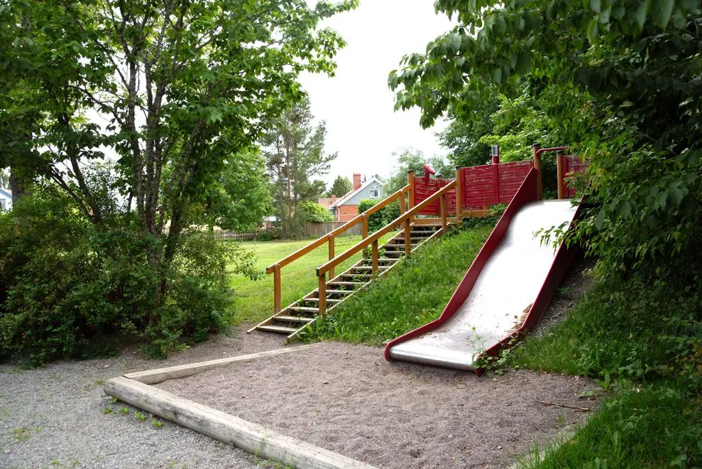 Lekplats med röd rutschkana och sandlåda