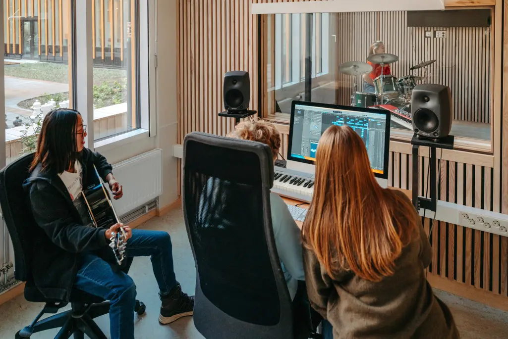 Foto på elever på estetiska programmet, de sitter i en musikstudio.