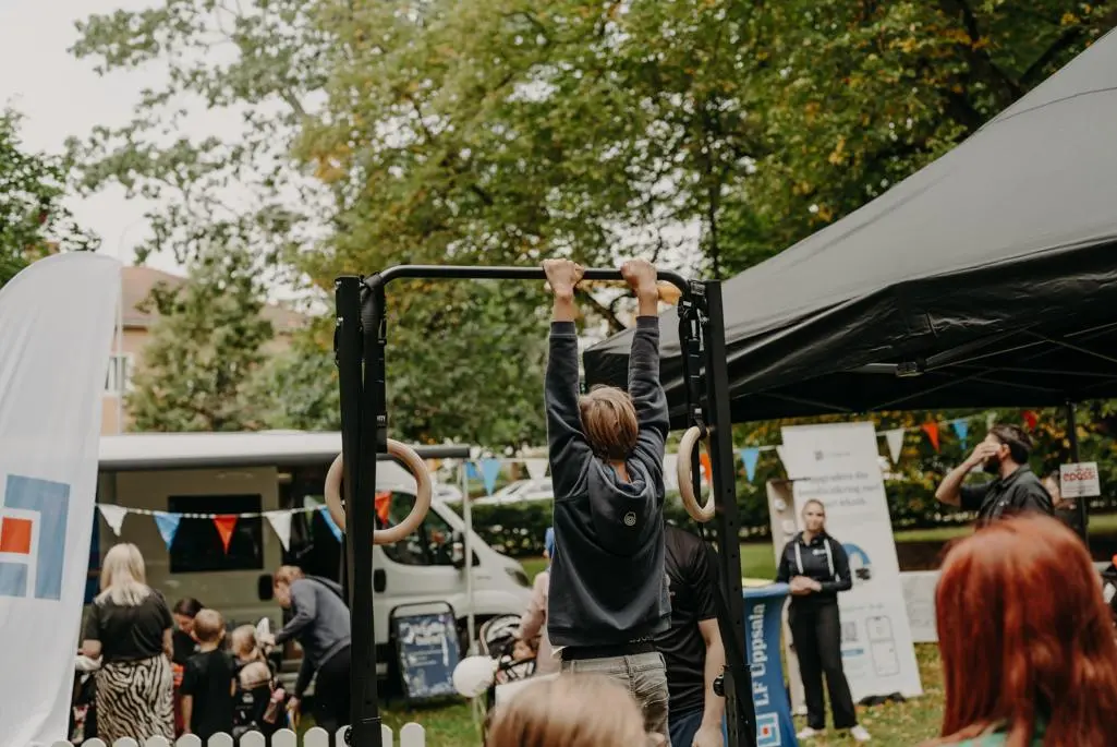 Foto på pojke som hänger i gymnastikringar.