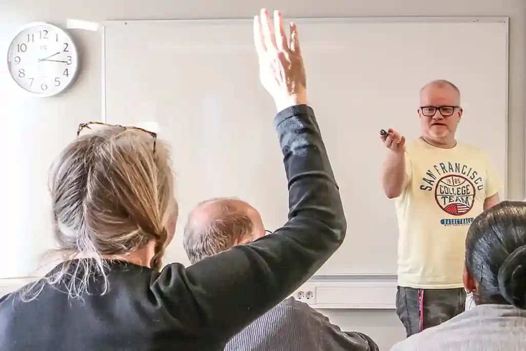 Elever sitter framför en lärare