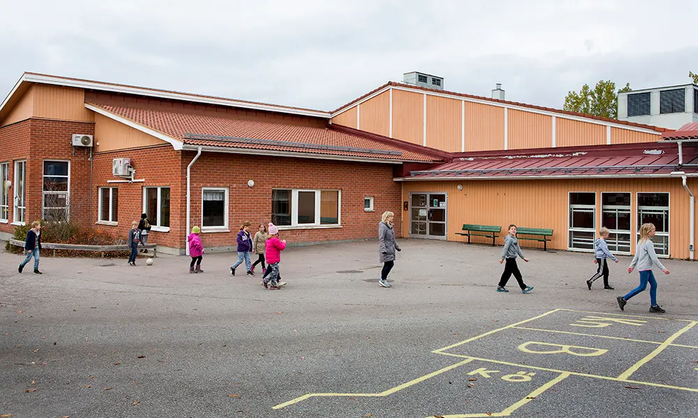 Foto av Fjärdhundraskolan. Det är en byggnad av tegel och trä.