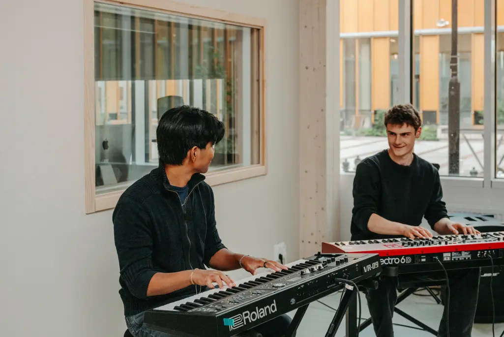 Två killar spelar keyboard, foto