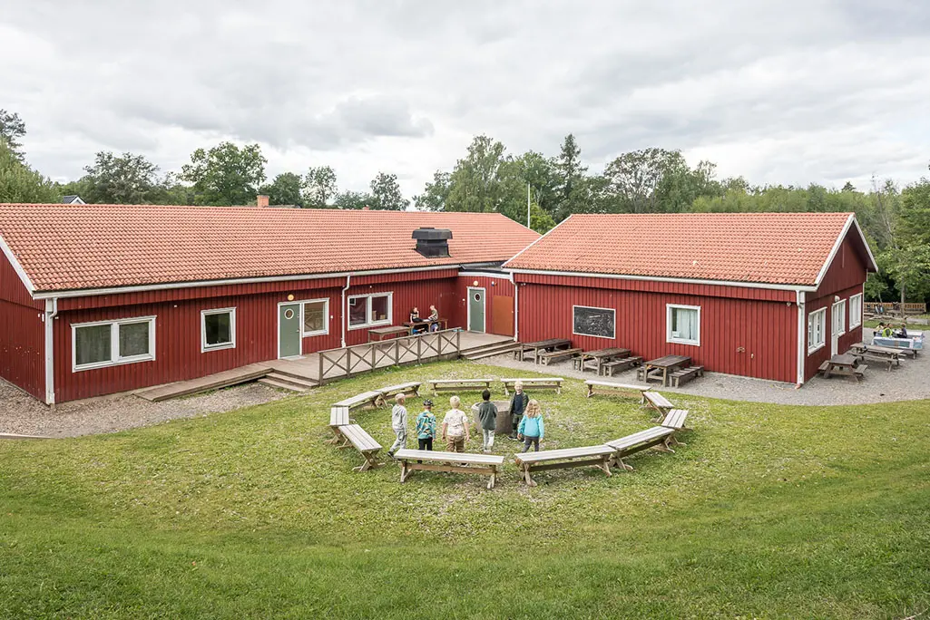 Foto av Robinson Fanna. Det är två röda träbyggnader med vita knutar.