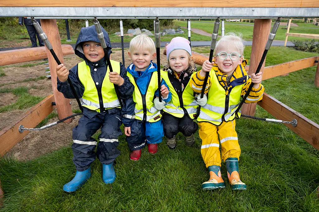 Foto på flera barn som sitter på förskolans skolgård.