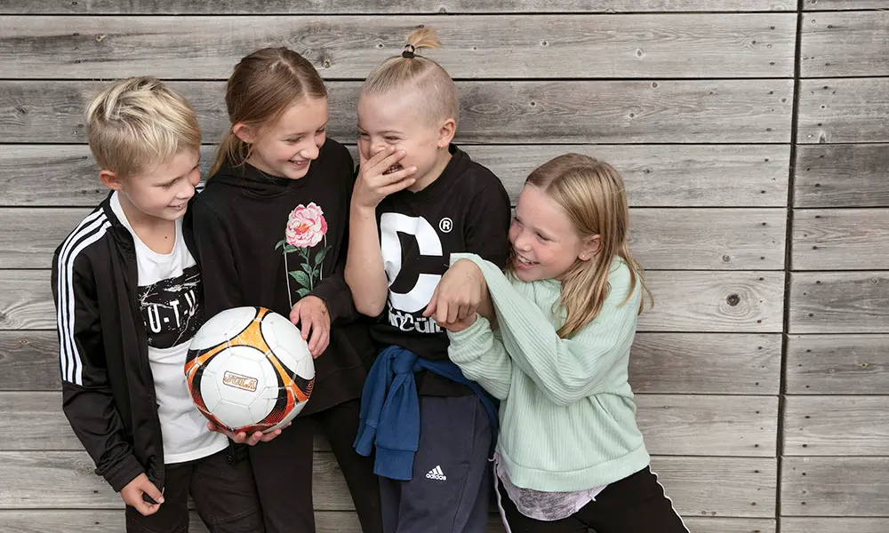 Foto av fyra elever som skrattar tillsammans.