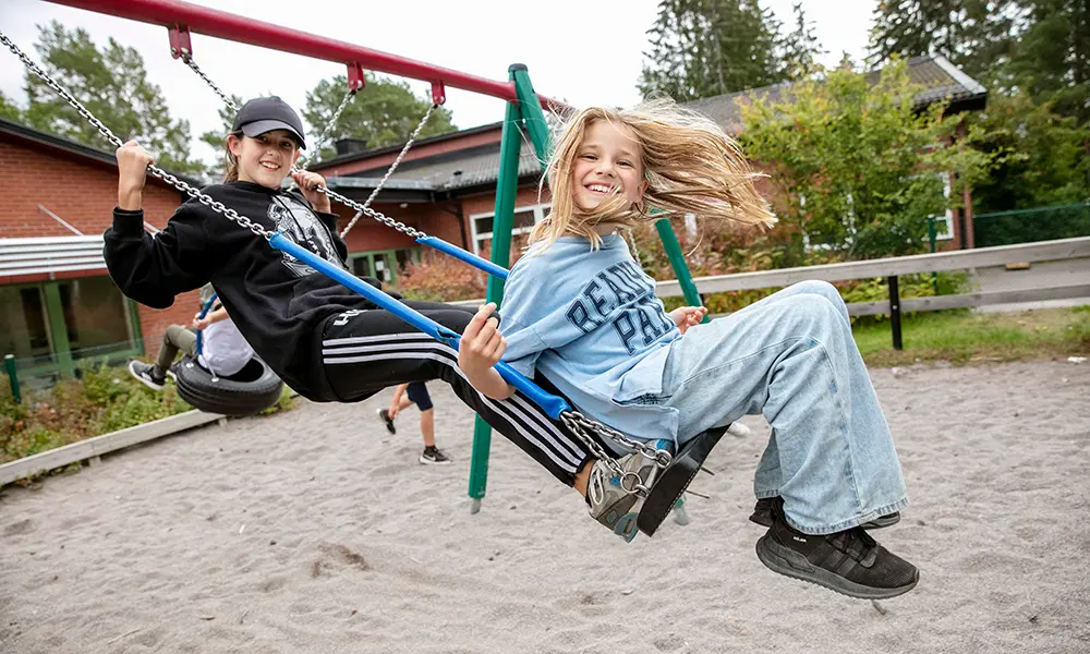Foto på två elever som gungar.